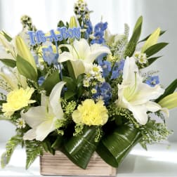 Blue and white floral arrangement with a "It's a Boy" sign in a wooden box