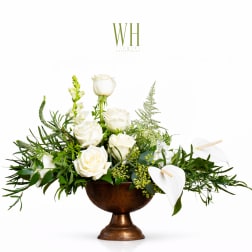 White roses and calla lilies in a bronze pedestal bowl