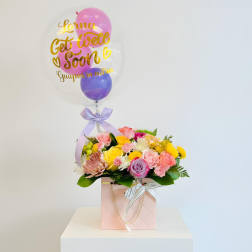 Pink and yellow flower arrangement with a clear balloon reading "Get Well Soon"