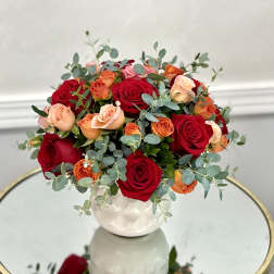 Bouquet of red and peach roses in a white vase