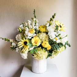 Yellow and white floral arrangement in a ribbed white vase