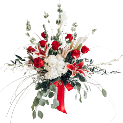 Red roses and white lilies in a tall vase with a red ribbon