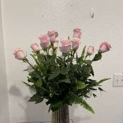 Pink roses arranged in a tall ribbed glass vase