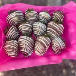 Box of chocolate-covered strawberries wrapped in bright pink paper
