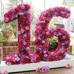 Large floral number 16 covered in pink, red, and purple blooms