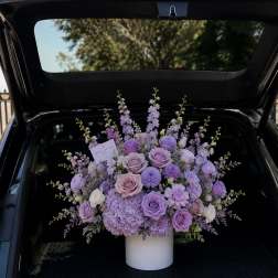 Lavender rose and hydrangea arrangement in a white vase
