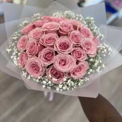 Bouquet of pink roses with white baby's breath in translucent wrap