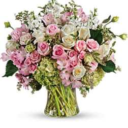 Pink and white roses arranged in a clear glass vase
