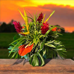 Tropical bouquet with red and orange blooms and long variegated leaves