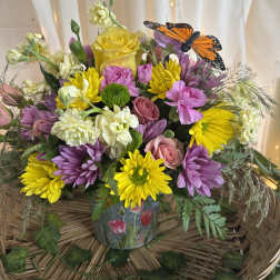Colorful bouquet in a glass vase with a butterfly decoration
