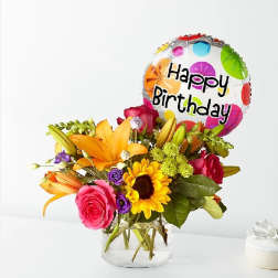 Mixed flower bouquet in a glass vase with a Happy Birthday balloon
