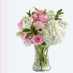 Pink roses and white hydrangeas in a clear glass vase