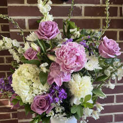 Pink roses and peonies in a white vase with white and purple flowers