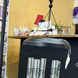 Silver memorial wind chime hanging indoors with black accents
