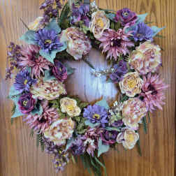 Heart-shaped floral wreath with pink, purple, and cream blooms