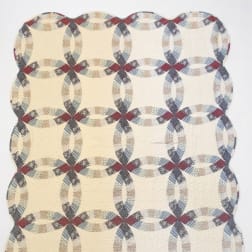Cream quilt with a repeating oval chain pattern in muted red, blue, and gray