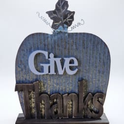 Decorative tabletop sign shaped like a pumpkin with the words Give Thanks