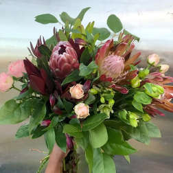 Large bouquet with pink protea, roses, and greenery