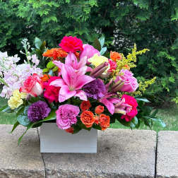 Colorful mixed flower arrangement in a white rectangular box