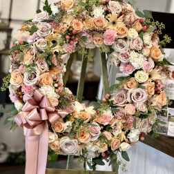 Large pastel floral wreath with a pink ribbon bow