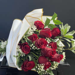 Bouquet of red roses with white filler flowers and white-gold wrapping