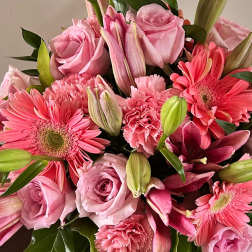 Pink roses, gerbera daisies, lilies, and carnations in a bouquet