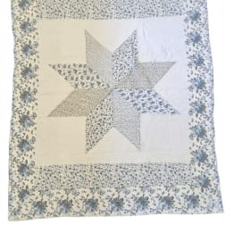 Patchwork quilt with a large star pattern and floral border