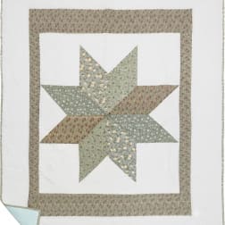 Patchwork quilt with a star pattern in muted floral fabrics