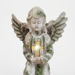 Stone angel figurine holding a glowing cross