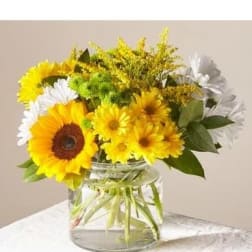 Sunflowers and white daisies in a clear glass vase