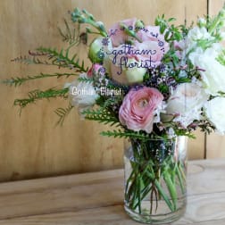 Pink and white flowers arranged in a clear glass vase