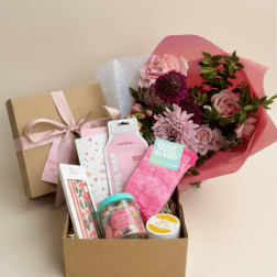 Gift box with pink flowers and assorted self-care items