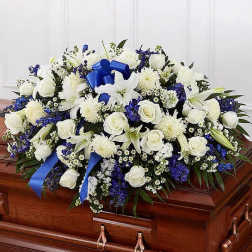White and blue funeral spray on a casket with a blue ribbon