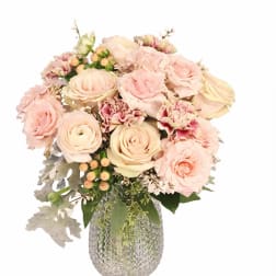 Blush roses and carnations in a textured glass vase