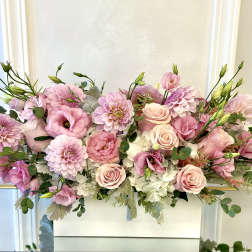 Pink and white floral arrangement with roses and dahlias in a white container