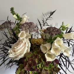 Cream roses and foxglove in a mixed floral arrangement
