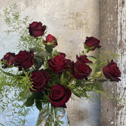 Bouquet of dark red roses in a clear glass vase