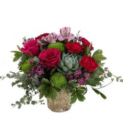 Bouquet of pink and red flowers in a textured vase