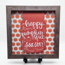 Framed fall sign reading "happy pumpkin spice season" with pumpkin pattern