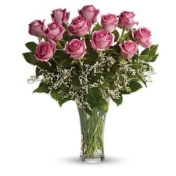 Pink roses arranged in a clear glass vase with white filler flowers