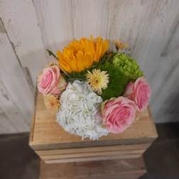 Mixed bouquet with pink roses, white hydrangea, and orange blooms