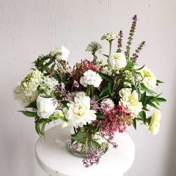 Mixed white and pink flowers arranged in a clear glass vase