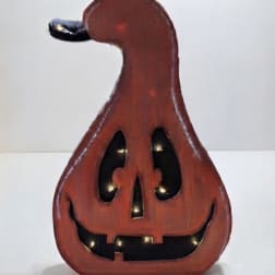 Wooden jack-o'-lantern decoration with a carved smiling face