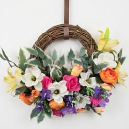 Floral wreath with colorful blooms on a grapevine ring