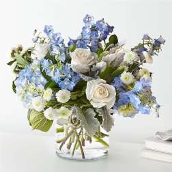 Blue and white flower arrangement in a clear glass vase