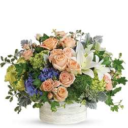 Peach roses and white lilies in a low white container