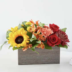 Mixed bouquet in a rectangular wood-look box with sunflowers and red roses