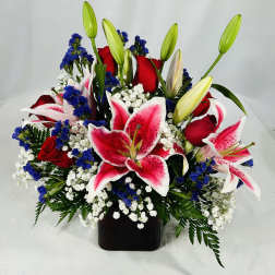 Bouquet of red roses and pink lilies in a black vase