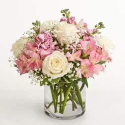 Pink and white bouquet of roses and alstroemeria in a clear glass vase