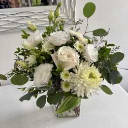 White floral bouquet in a clear square vase